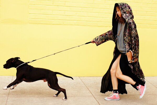 Chica en un paseo con un perro con una correa