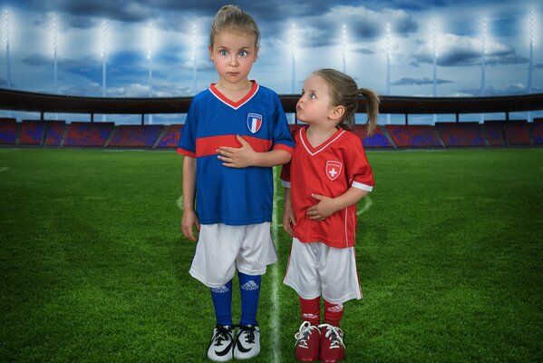 Kleine Kinder in sportlicher Uniform auf dem Fußballplatz