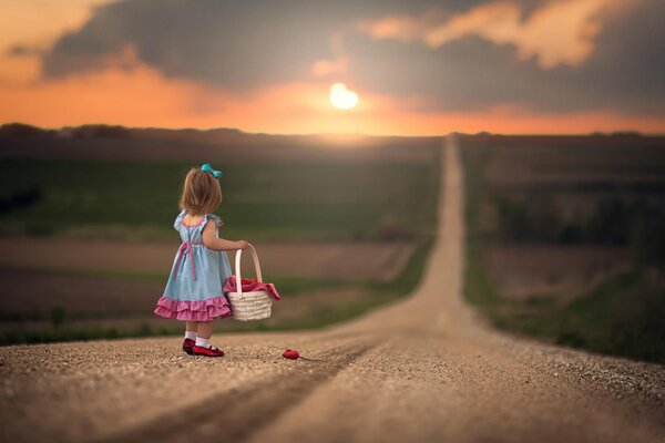 A girl on her way into the sunset with a basket