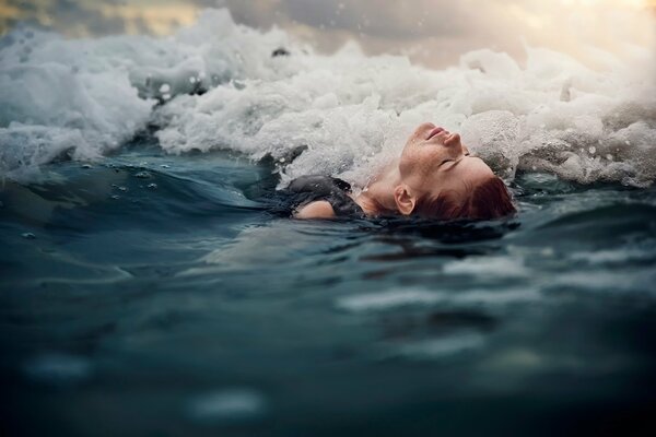 La ragazza si trova sulla schiena nel surf