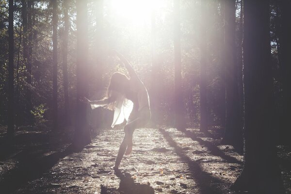 Girl dancing in a white dress in the rays of the sun husband