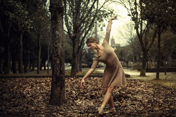 Chica bailando en el follaje de otoño