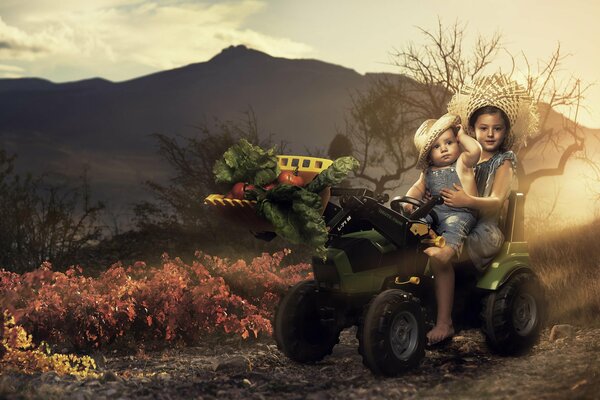 Les enfants sur le tracteur transportant des légumes