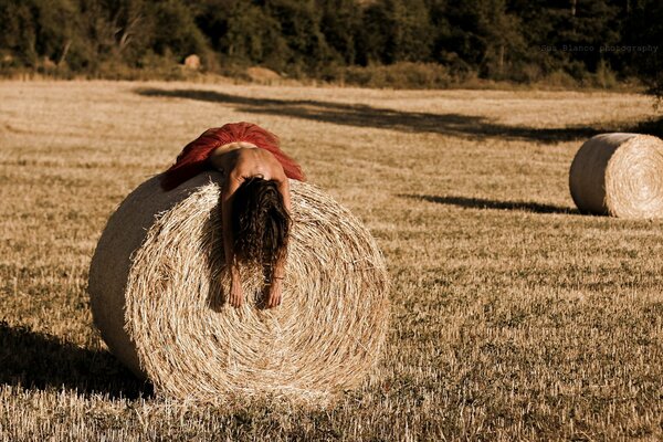 Девушка лежит на стоге сена