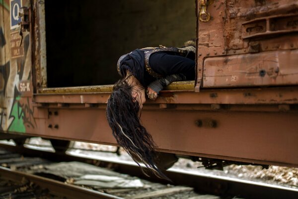 Dziewczyna spuściła głowę z wagonu pociągu