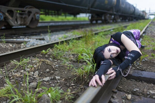 Fille se trouve sur un rail de chemin de fer