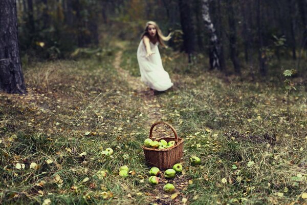 Una niña corre hacia una cesta de manzanas