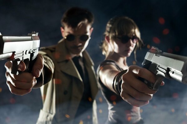 A guy and a girl with glasses with pistols