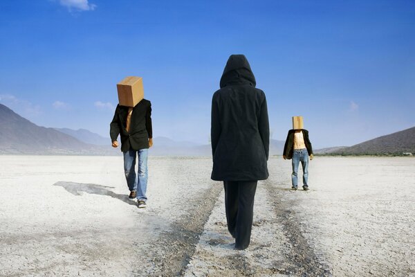 Two men are walking in the desert with boxes on their heads, a girl in a hood is walking towards them