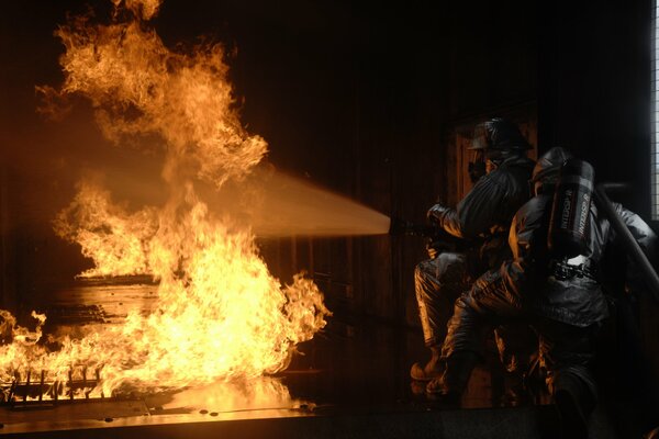 Strażacy w ekwipunku w pożarze