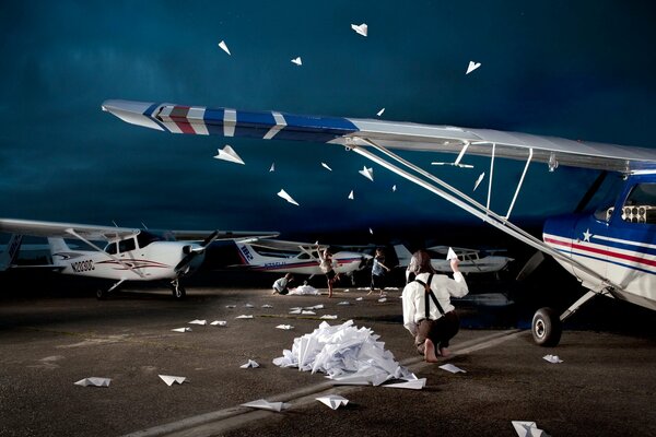 A man at the airport launches paper airplanes