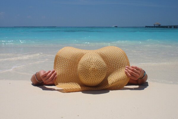 Chica con sombrero grande junto al mar