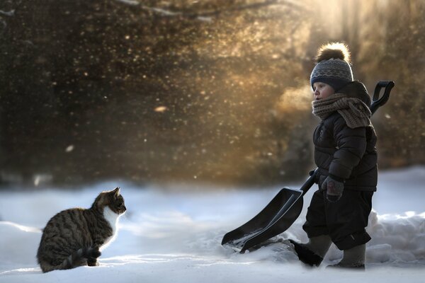 Bebé con gato salió a quitar la nieve