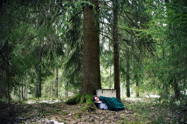 Mädchen schlafen in einem Koffer in einem geheimnisvollen Wald