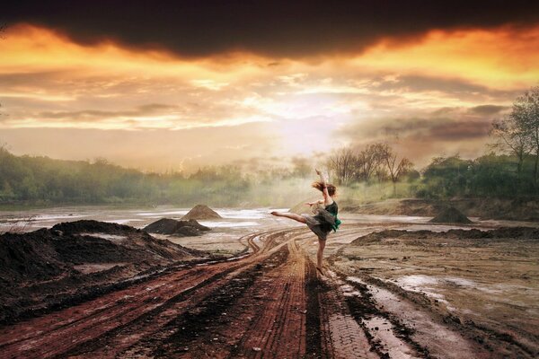 La jeune fille danse sur la route sous la pluie. Coucher de soleil orange