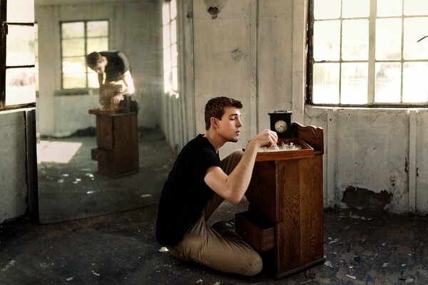 A guy in an abandoned house is playing chess with his reflection