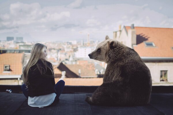 On the roof of the house a girl and a bear