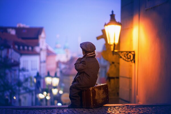 Junge mit Koffer in der Nachtstadt