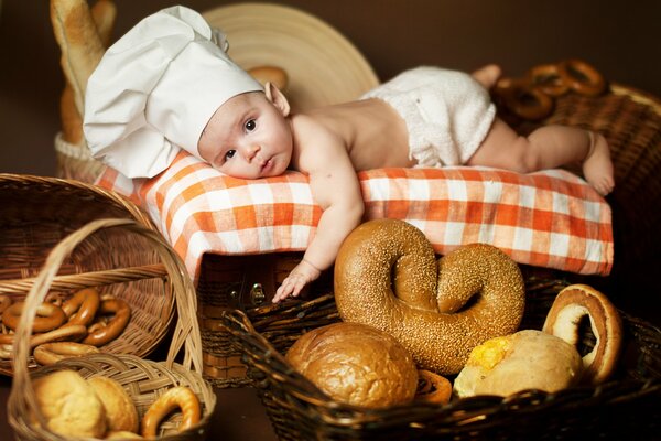 Малыш-пекарь лежит среди баранок