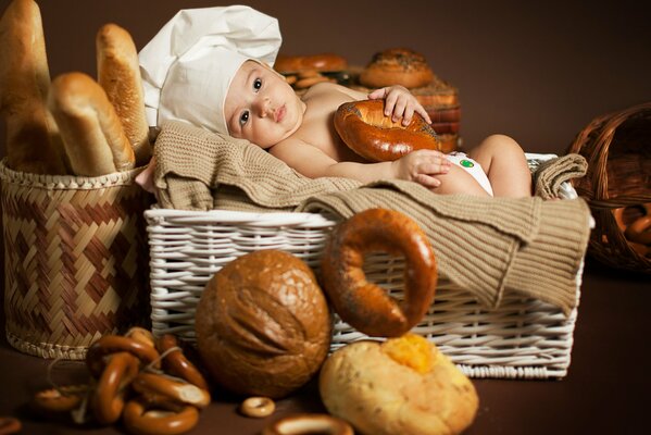 Tired kid cook in a basket with bread