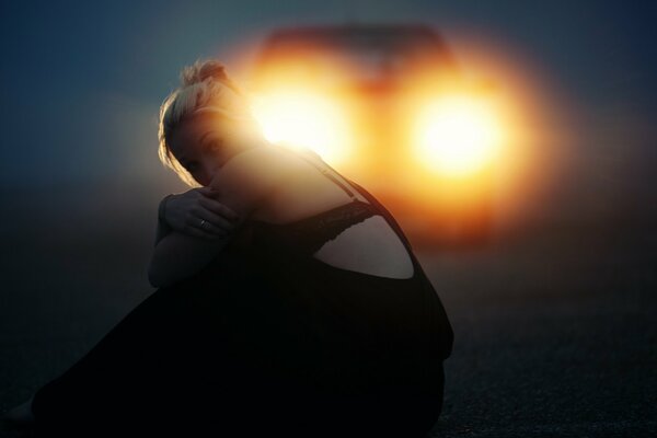 The girl was walking along the road, catching a car , already upset, sat down on the road , but fortunately the car stopped