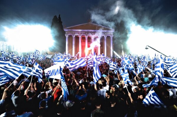 Manifestantes en la calle con banderas por la noche