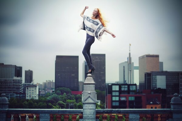 A red-haired slender girl stands on a peak