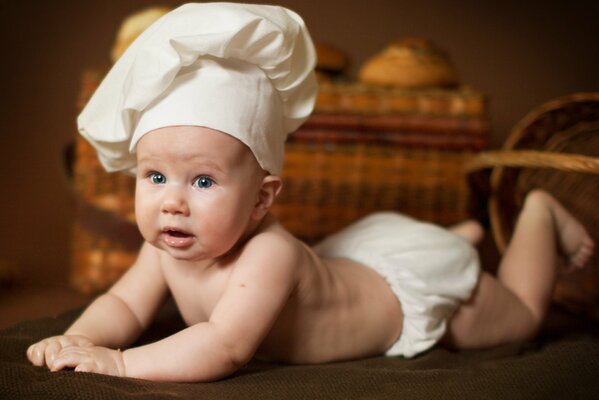 A child in a chef s hat on the background of baskets