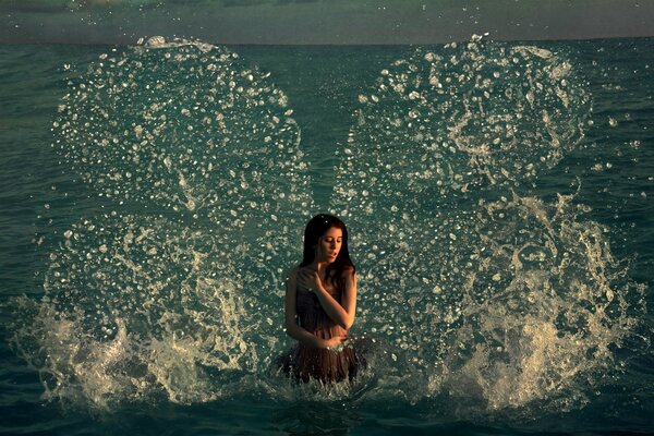 A girl with butterfly wings made of water droplets