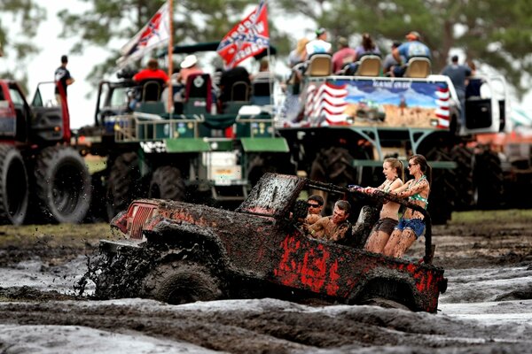 Outdoor wrecker rides through the mud with people