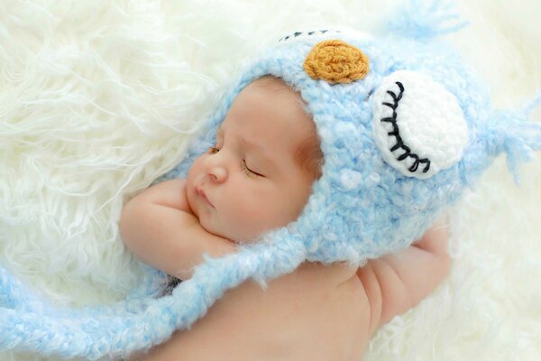 Pequeño bebé durmiendo en un gorro azul