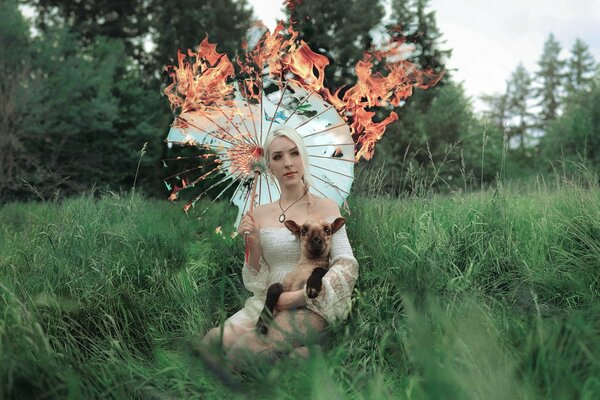 A girl in nature with a sheep and an umbrella