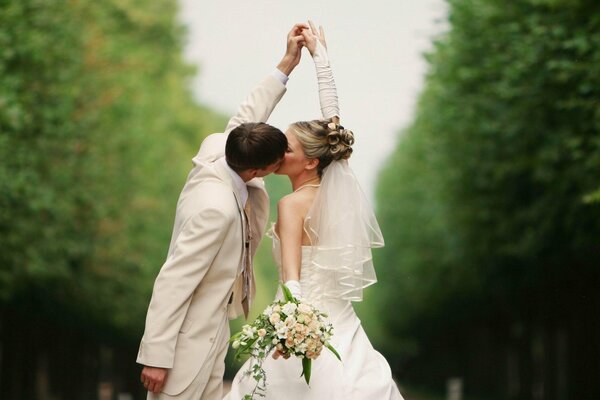 Wedding photo of newlyweds kissing holding hands
