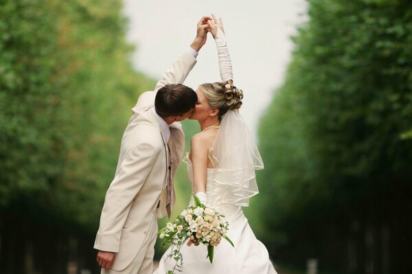 Foto de la boda de los recién casados besándose de la mano