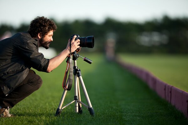 Curly-haired man with a beard and a camera