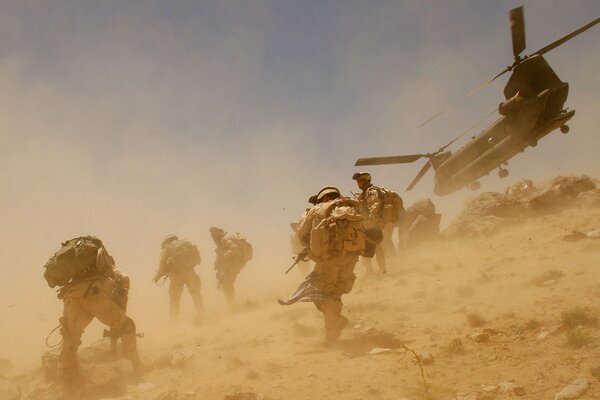 A desert storm. Fighting. People and helicopters are waging war