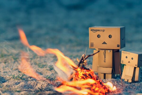 Un par de hombres de cartón danbo tomando el sol junto al fuego