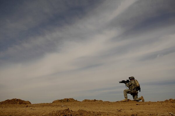 Soldado en el desierto en tierra y piedras