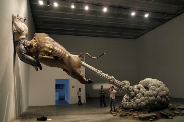 Statue of a farting bull on the background of people