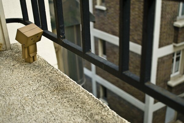 Danbo vicino alla recinzione del balcone della casa