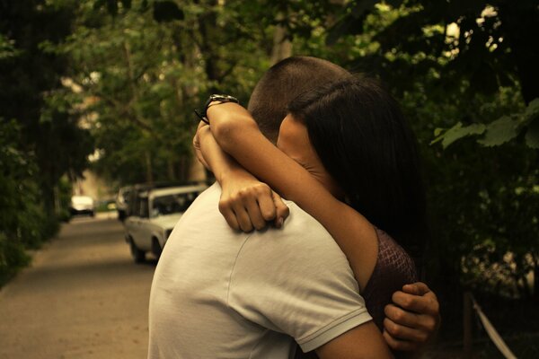 A girl and a guy hug in the park