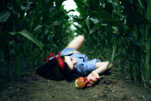 Fille avec une pomme se trouvant dans le champ