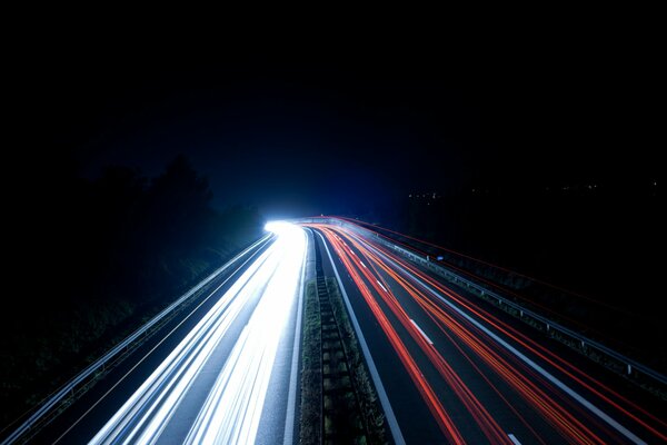 Luz borrosa de los coches en la carretera nocturna