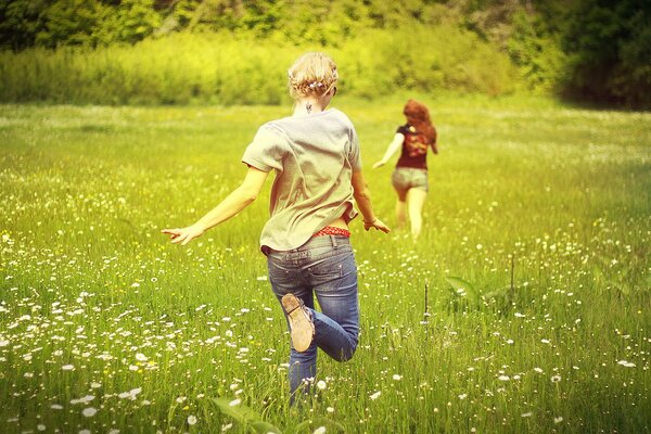 Running girls in a field of daisies