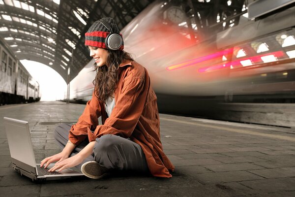 Chica se envía mensajes de texto en la plataforma de la estación