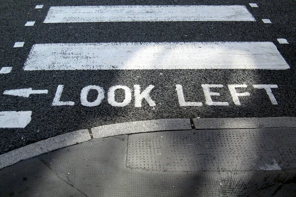 An inscription in English in front of a pedestrian crossing with an arrow drawn and the words look to the left