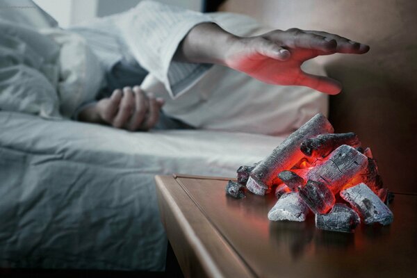 A man touches hot coals