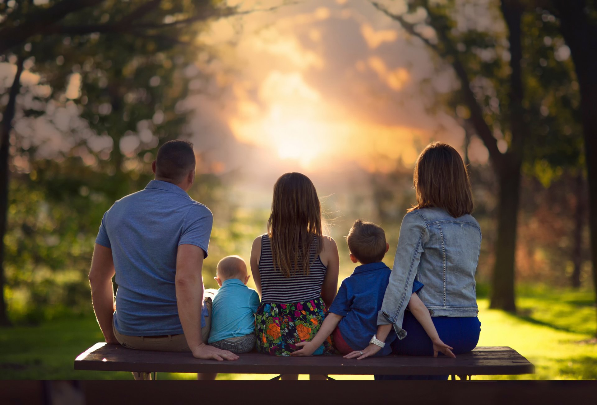 familia niños padres banco puesta de sol