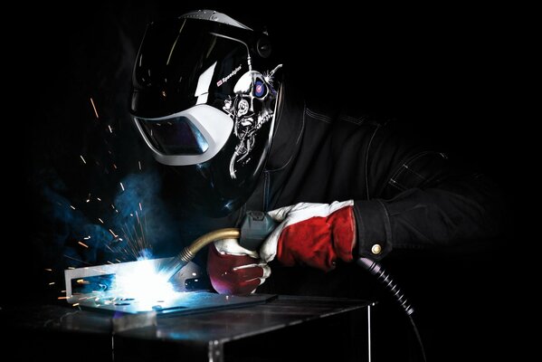 A welder in a black mask at work