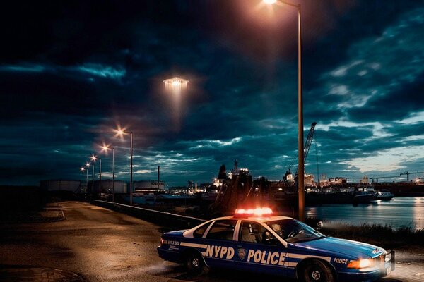A police car is driving through the night city